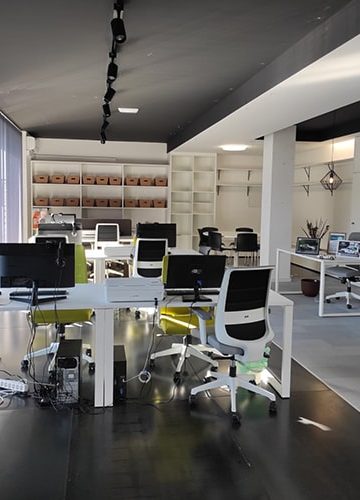 Interior do espaço de Coworking com várias mesas e computadores e postos de trabalho